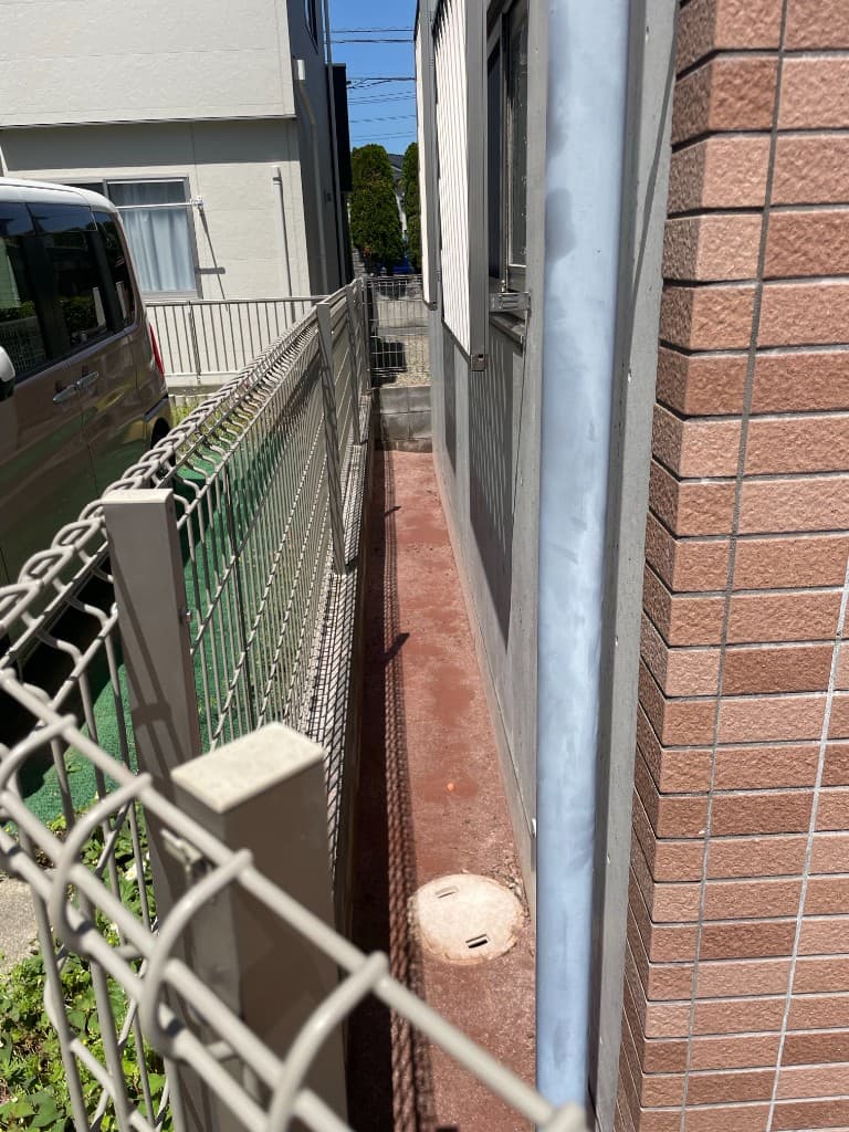 防草土施工後の建物側面の細い通路